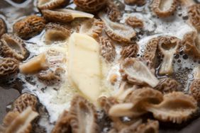 Morel mushrooms sauteeing in butter in a pain