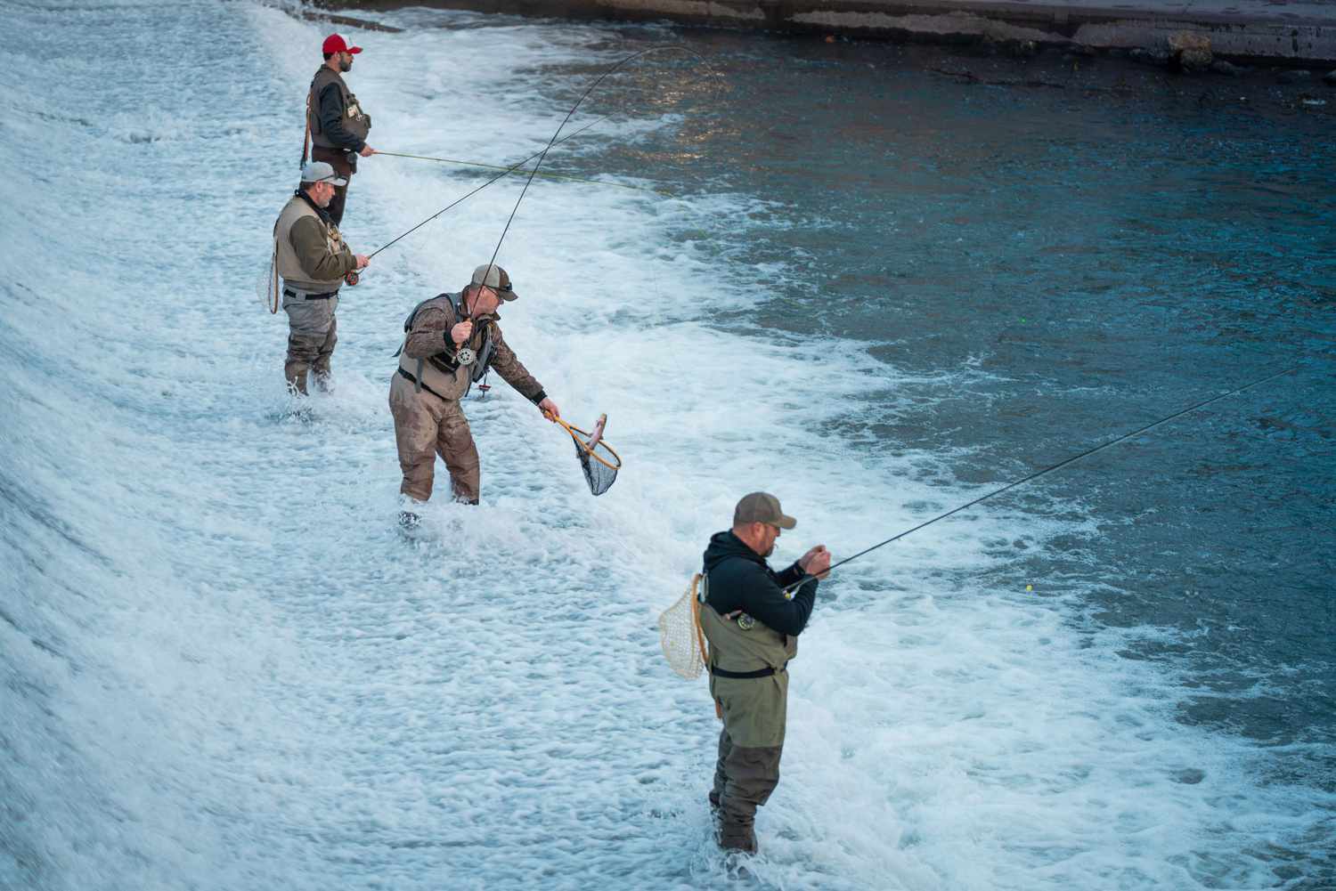 Fishermen in front of waterfall at Bennett Spring State Park in Missouri