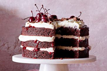 Three layers of Black Forest Cake with jam and frosting and cherries