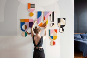 Emily Van Hoff hanging quilt on wall