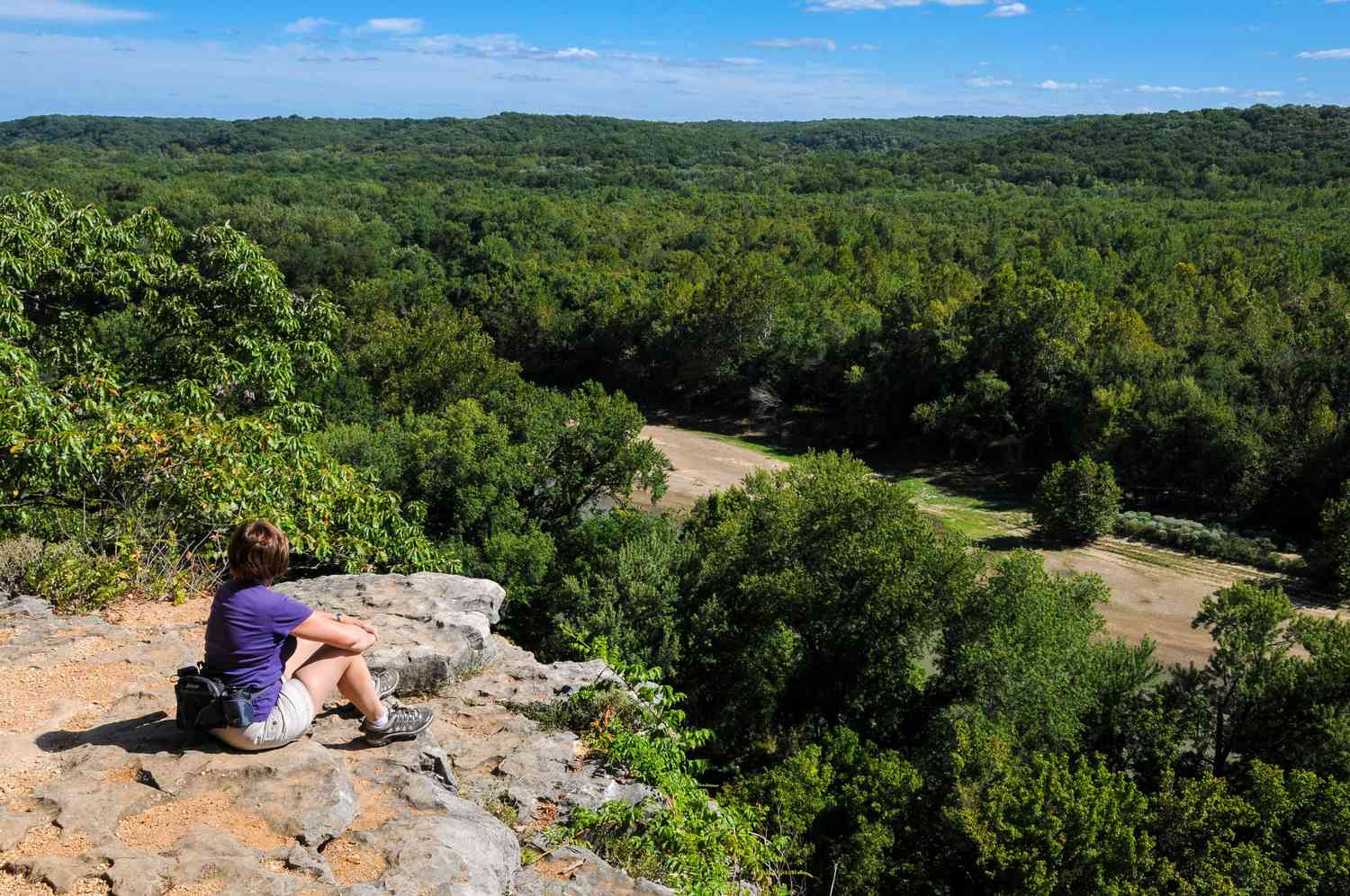 Woman looking out from rocky point across Castlewood State Park in Missouri