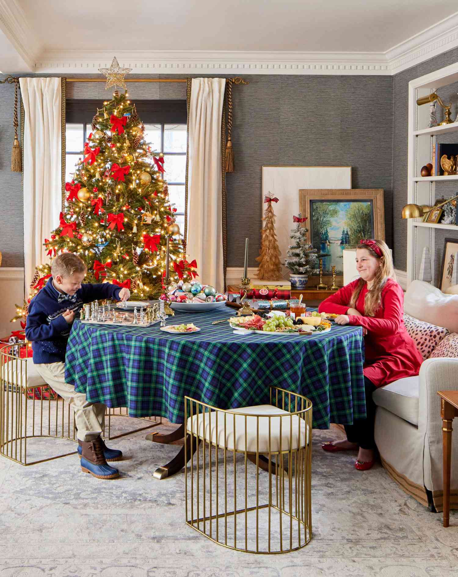 Children around a game table in front of a Christmas tree