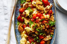 oval dish of Roasted Cauliflower and Tomatoes with Olives and Garlic Breadcrumbs