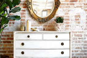 white refinished dresser brick wall mirror